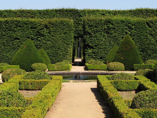 large garden with green hedges and a fountain